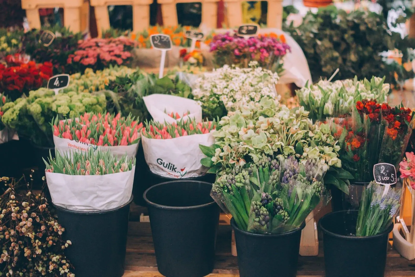 Étal de fleuriste garni de bottes de fleurs fraîches et d'étiquettes de prix